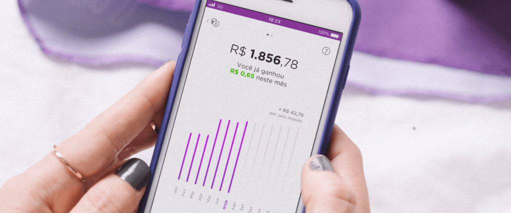 Mão segurando celular com o aplicativo Nubank aberto na área da NuConta