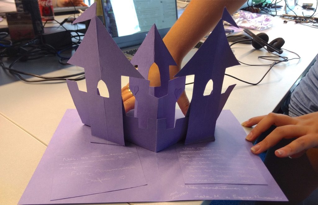 Cartinha escrita à mão em papel roxo, em forma de castelo.