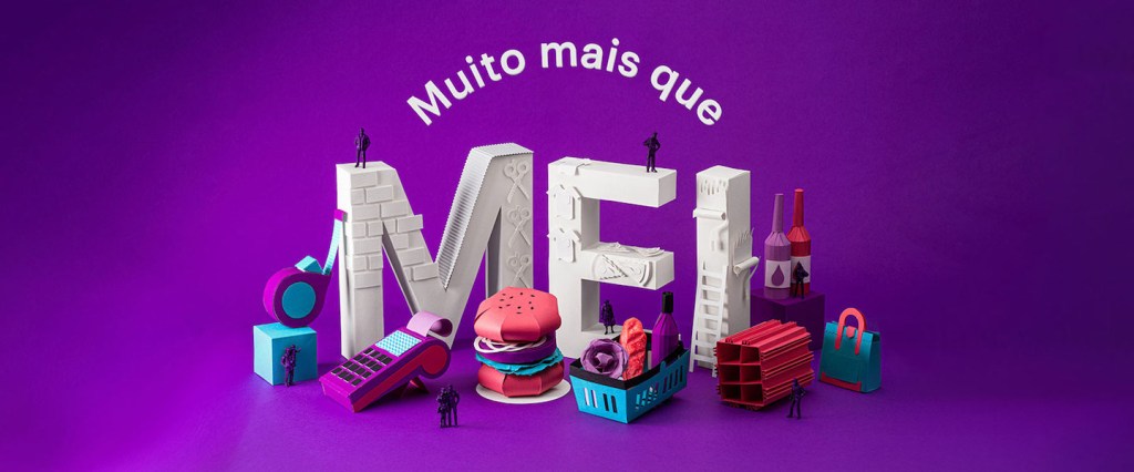 Data Nubank MEI: esculturas em papel formam a palavra MEI e outros objetos deste universo, como uma máquina de cartão, um hambúrguer, uma sacola e um tijolo. Pequenas figuras humanas de plástico também estão espalhadas. Ao todo, lê-se Muito Mais que MEI