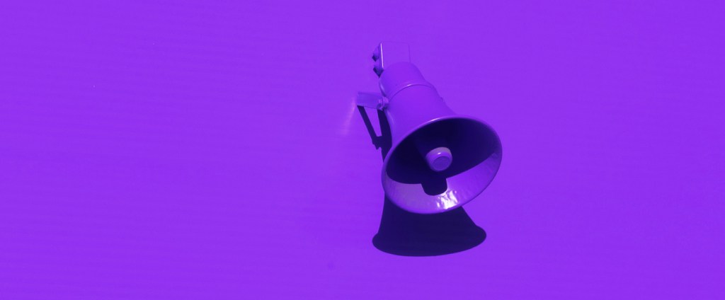 Ações preferenciais: Imagem mostra um megafone roxo sobre um fundo roxo.