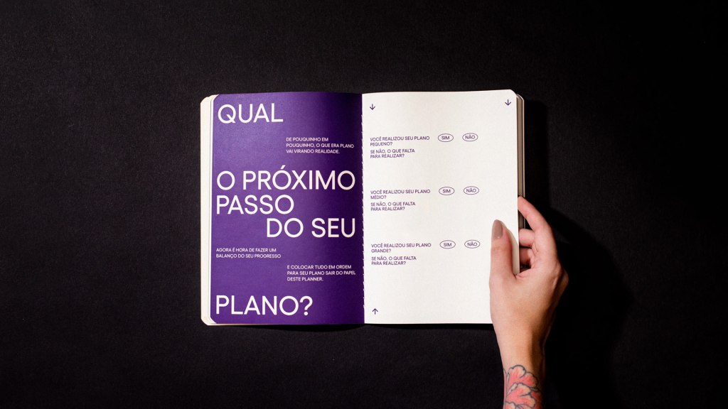 uma mão segurando o planner aberto