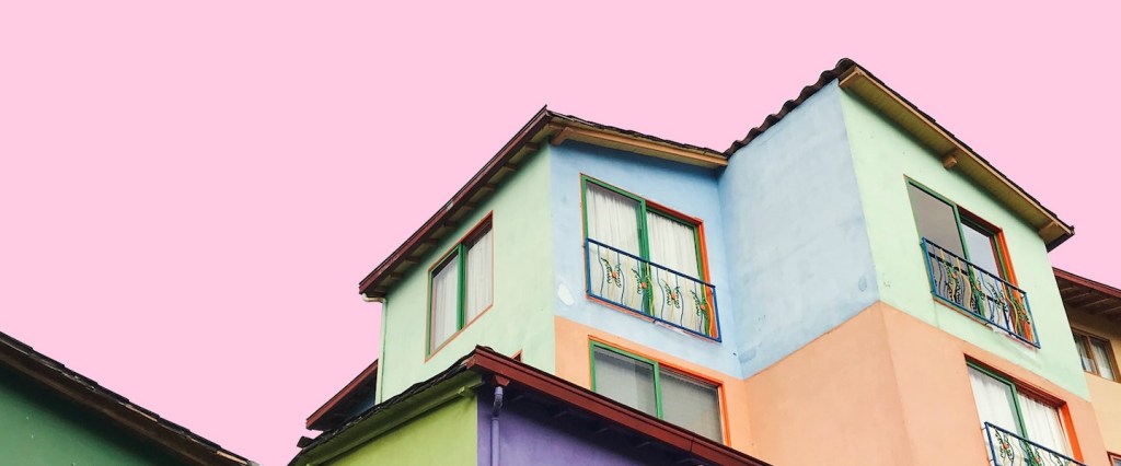 imagem de casas coloridas em um fundo rosa claro. Foto: Nubia Navarro