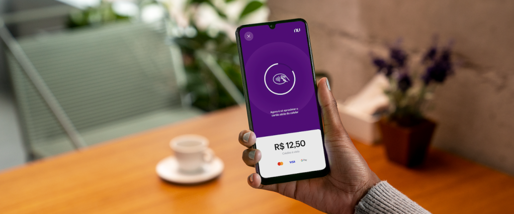 Como fazer uma cobrança pelo NuTap: na foto, vemos uma mão segurando um celular onde é possível ver a tela de cobrança do NuTap